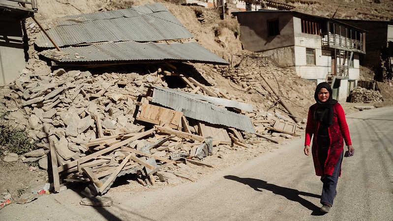 在尼泊尔朱姆拉省，一名年轻女子走过因暴雨引发的山体滑坡而倒塌的房屋