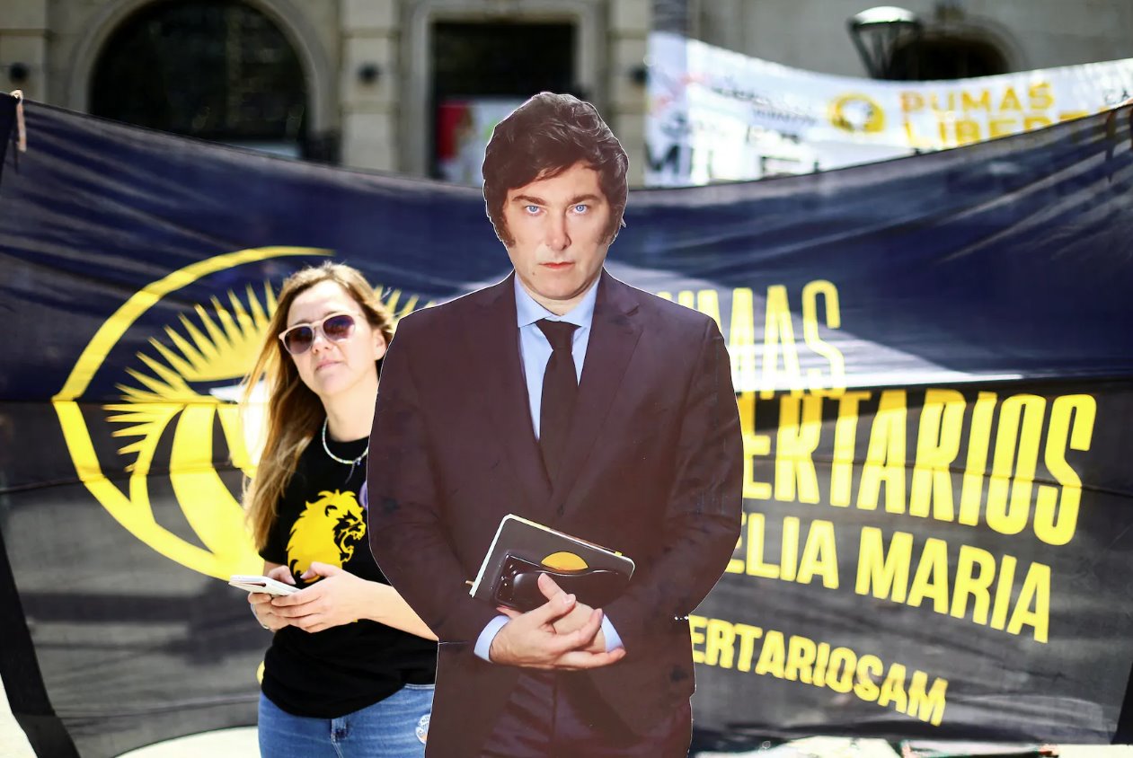 一名妇女走在阿根廷总统候选人哈维尔·米莱(JavierMilei)的剪影旁边