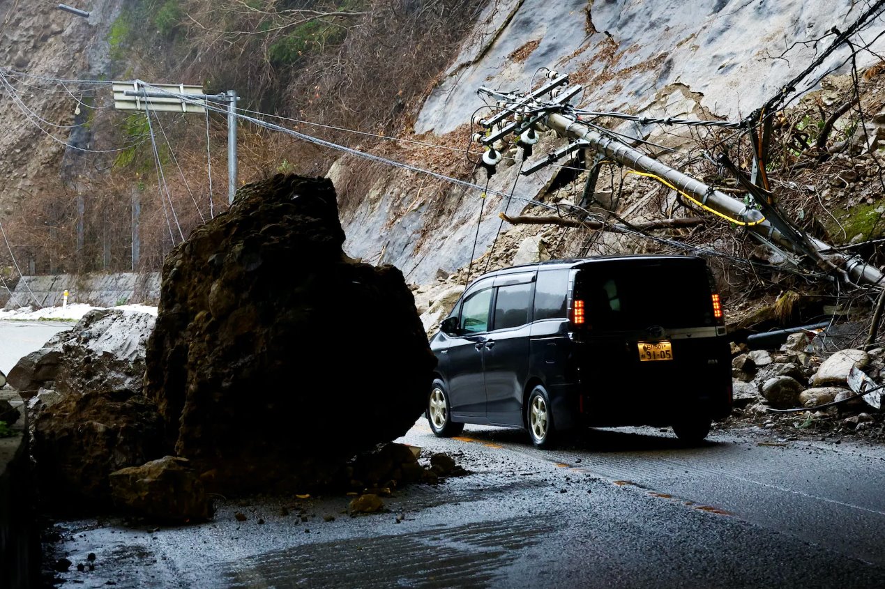 2024年1月3日，日本轮岛，地震后，一辆汽车在受损的道路上行驶。