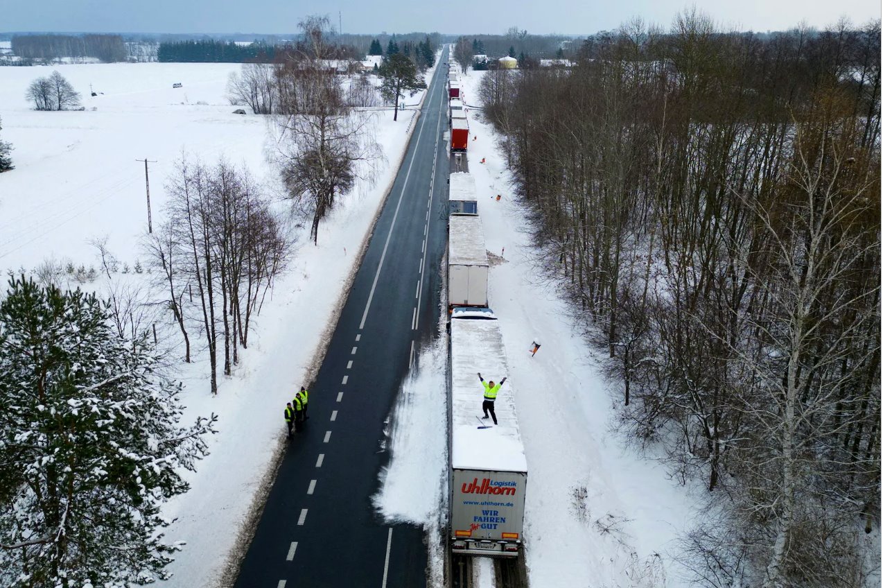 2023年12月4日，波兰奥科皮，一名乌克兰卡车司机在Dorohusk-Jagodzin过境点排着长队，在车顶挥手致意。
