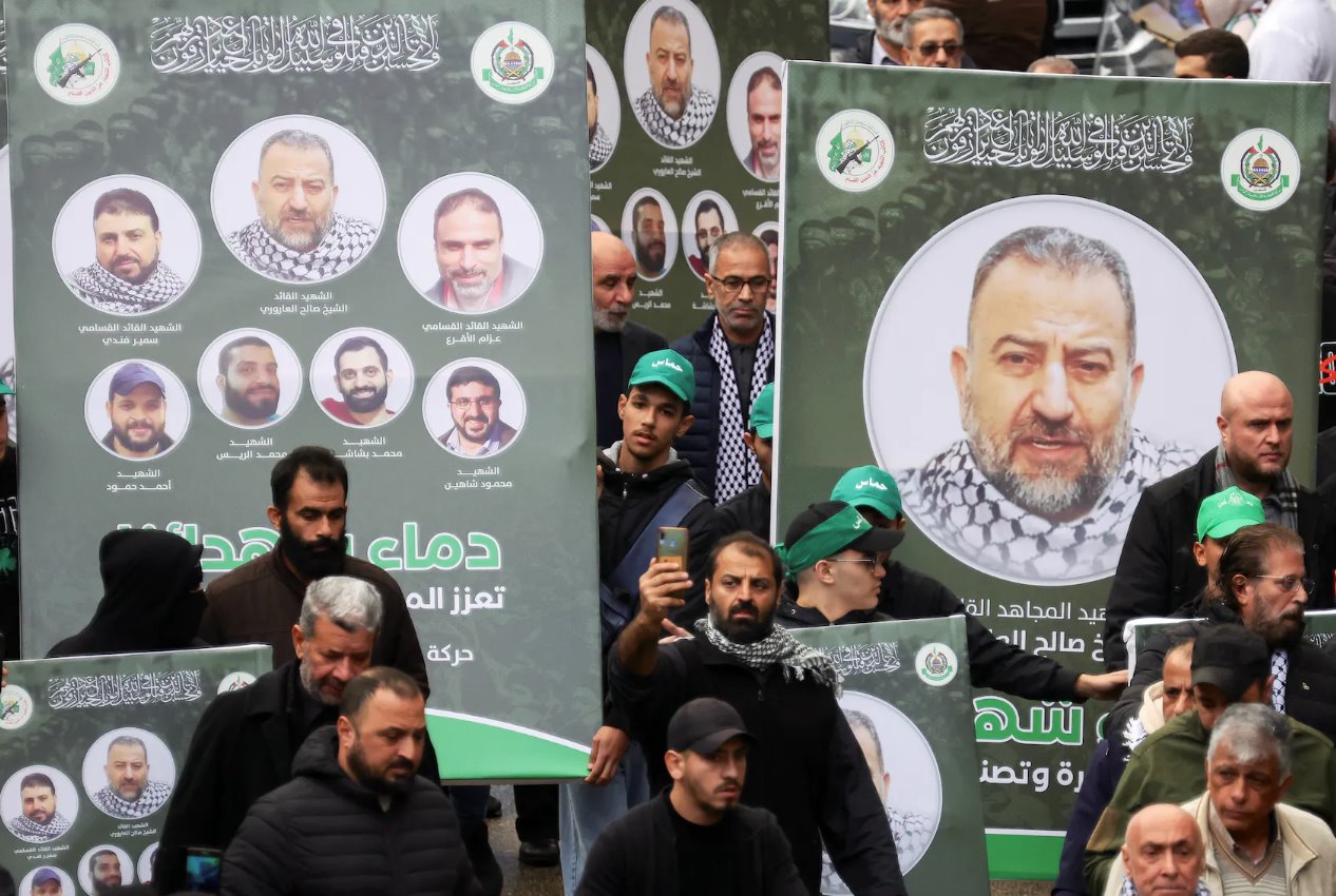 2024年1月4日，黎巴嫩贝鲁特，哀悼者聚集在他的葬礼上，人们举着印有哈马斯副领导人萨利赫·阿鲁里(Salehal-Arouri)照片的标语牌。