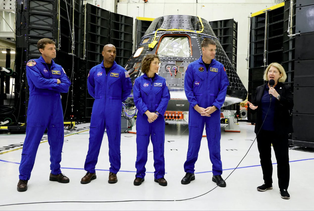 美国宇航局阿耳忒弥斯二号任务的宇航员站在他们的猎户座乘员舱前