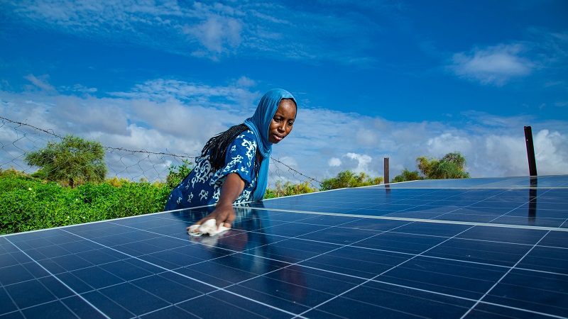 毛里塔尼亚南部富拉尼村的一名妇女正在清洁太阳能电池板