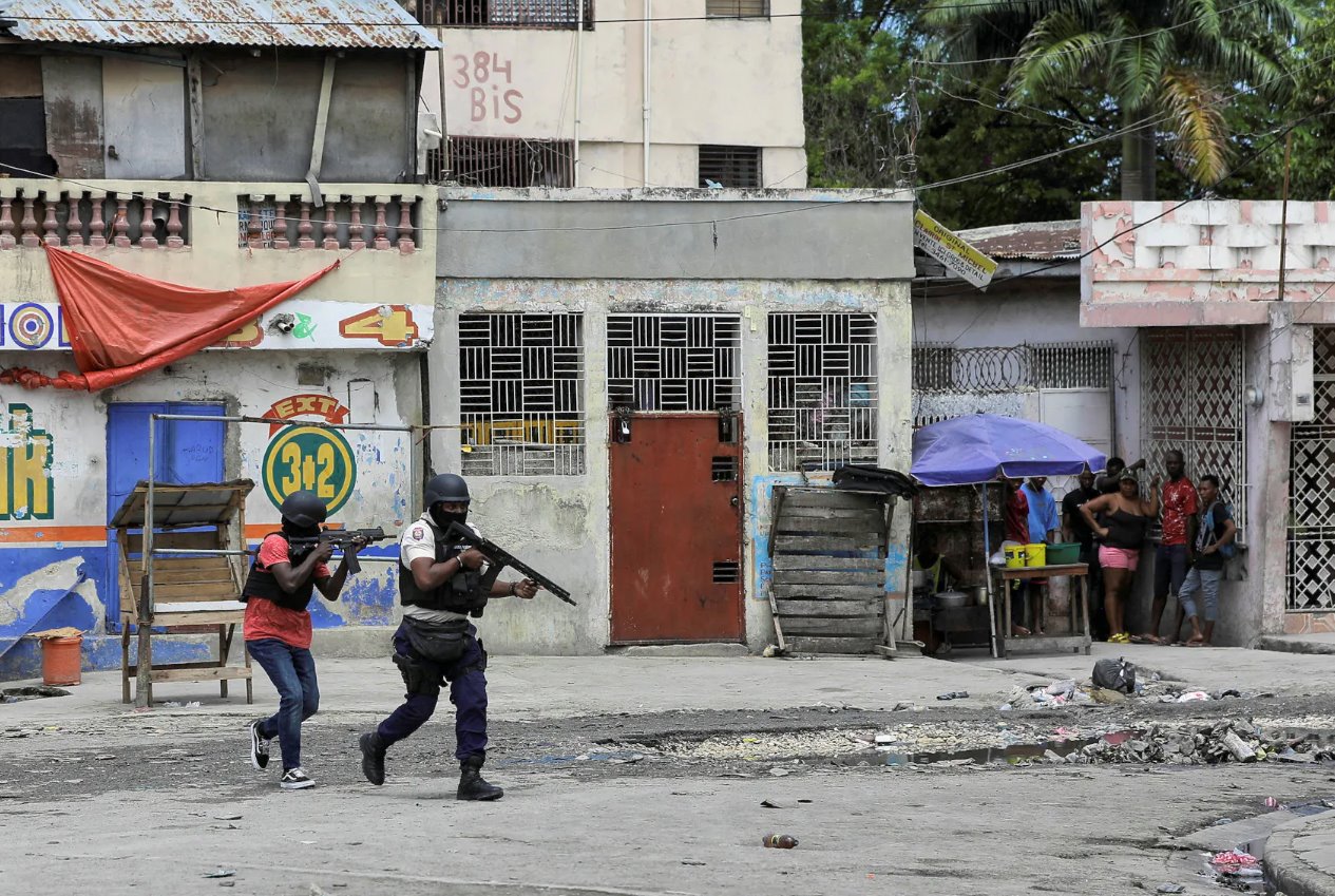 2023年4月25日，海地太子港，帮派成员试图袭击警察局，警察在街上巡逻，人们挤在角落里。