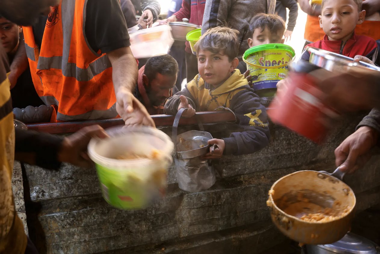 2024年1月16日，在加沙地带南部的拉法，以色列和巴勒斯坦伊斯兰组织哈马斯之间的冲突持续不断，巴勒斯坦人在食品供应短缺的情况下等待收到慈善提供的食物。
