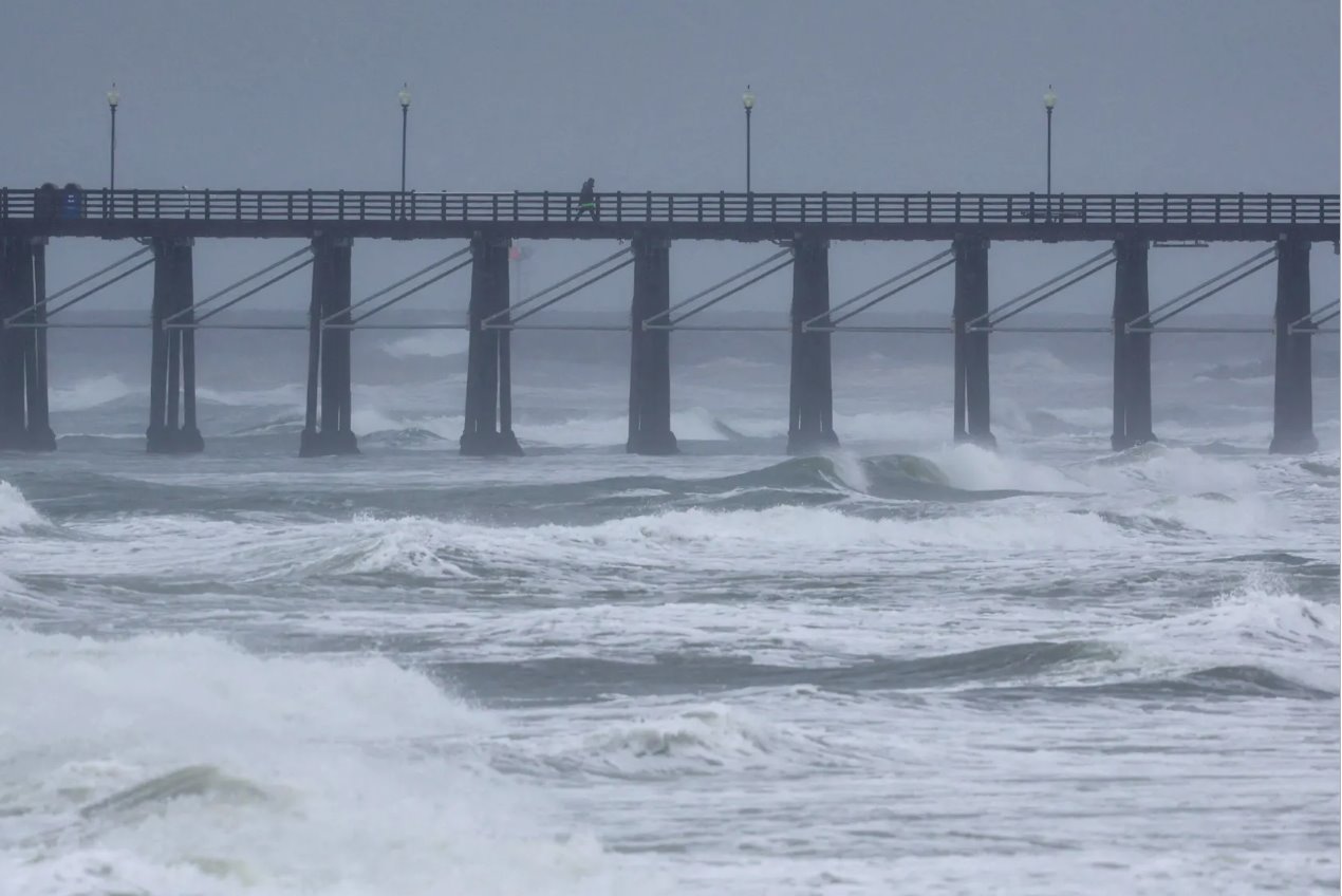 2024年2月6日，美国加利福尼亚州欧申赛德，一名人沿着码头行走，大气中的降雨继续影响着天气。