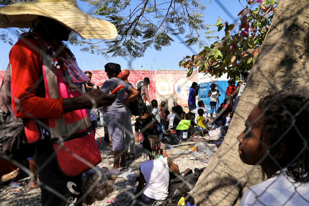 2024年2月12日，海地太子港，敌对帮派之间发生枪战后，逃离暴力的人们抵达海地国家警察局。