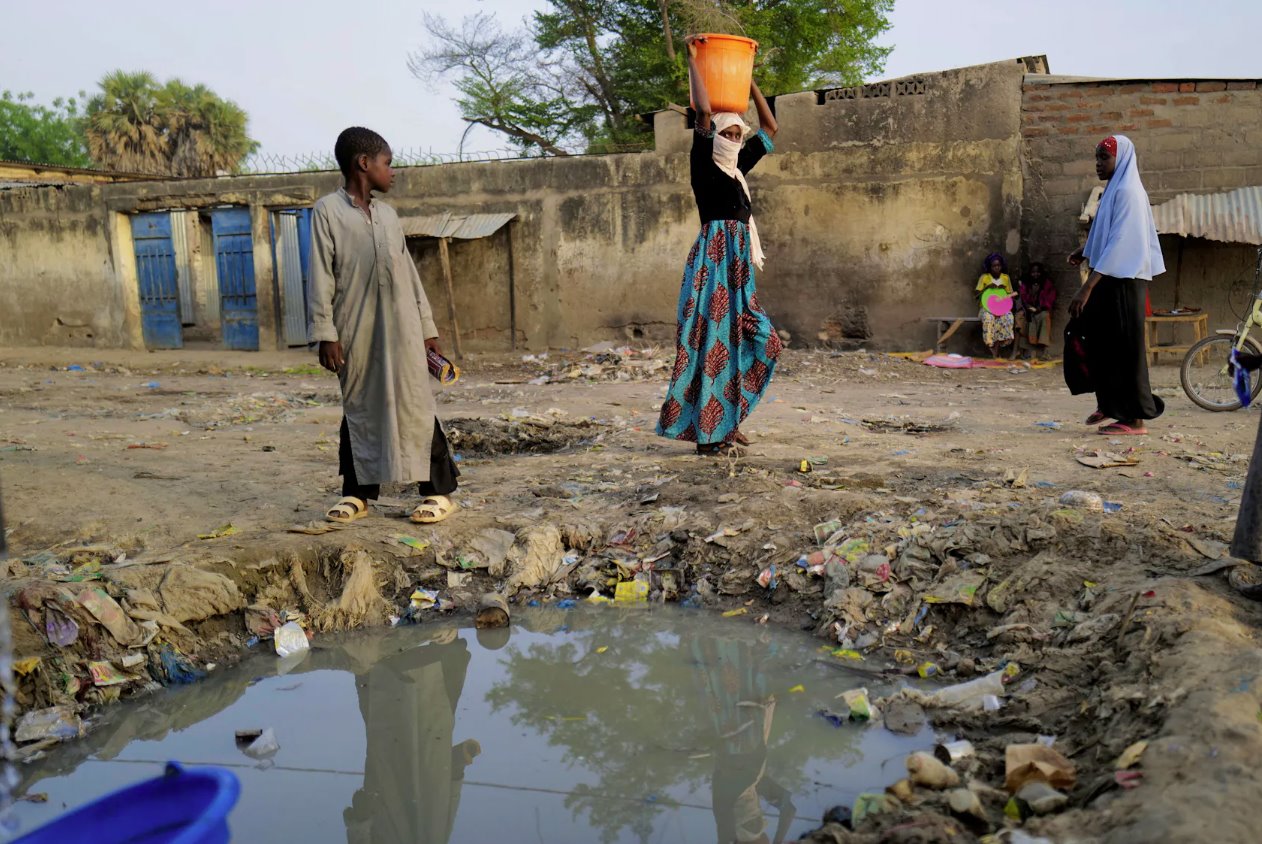 2021年4月25日，乍得恩贾梅纳的一个贫困社区，一名妇女拎着一个装满水的容器。