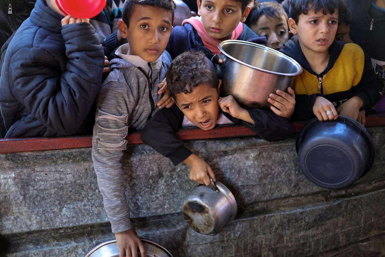 2024年2月5日，在加沙地带南部的拉法，巴勒斯坦儿童在等待领取慈善食物。