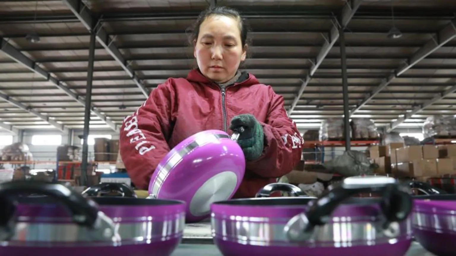 浙江省杭州市，一名妇女在一家生产铝制煎锅的工厂工作，煎锅用于出口。