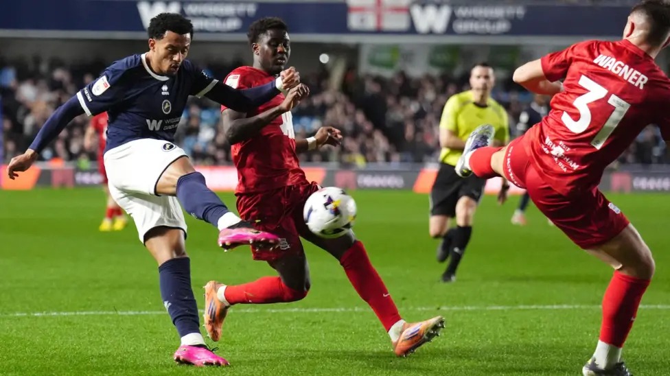 米尔沃尔队的费米·阿齐兹凌空抽射,伯明翰队的凯·瓦格纳抬脚试图封堵射门。